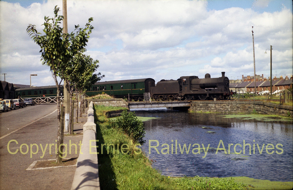 hc  Newry__crossing_the_Newry_Canal_at_Buttercrane_Quay_Ex_GNR_UG_UTA_No_49_heads_for_Warrenpoint_ca_1961
